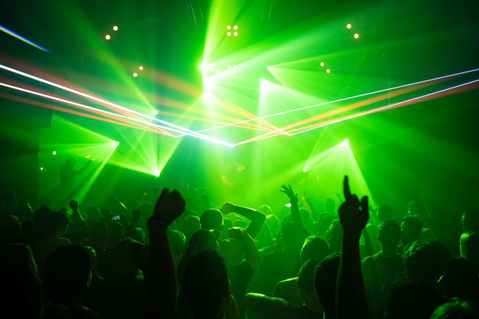 Crowd dancing under coloured lights at an electronic music event