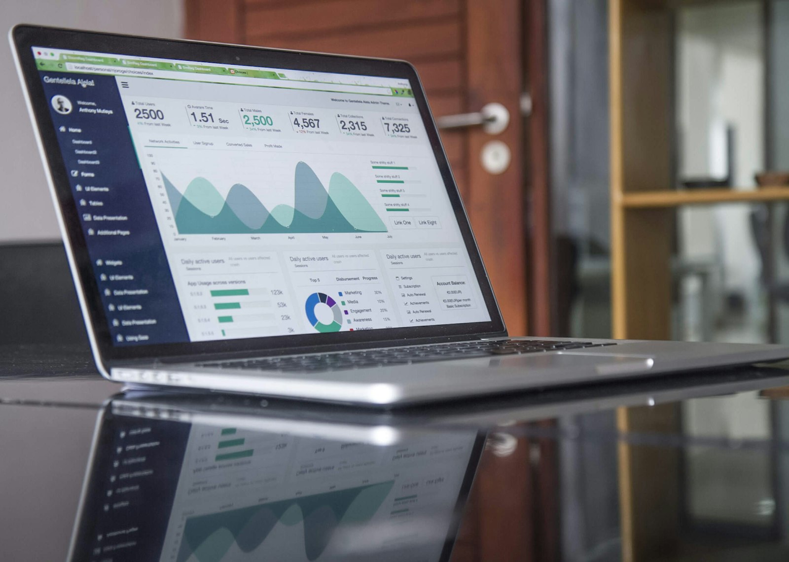 Laptop displaying marketing analytics beside a notebook, representing measurable search advertising.